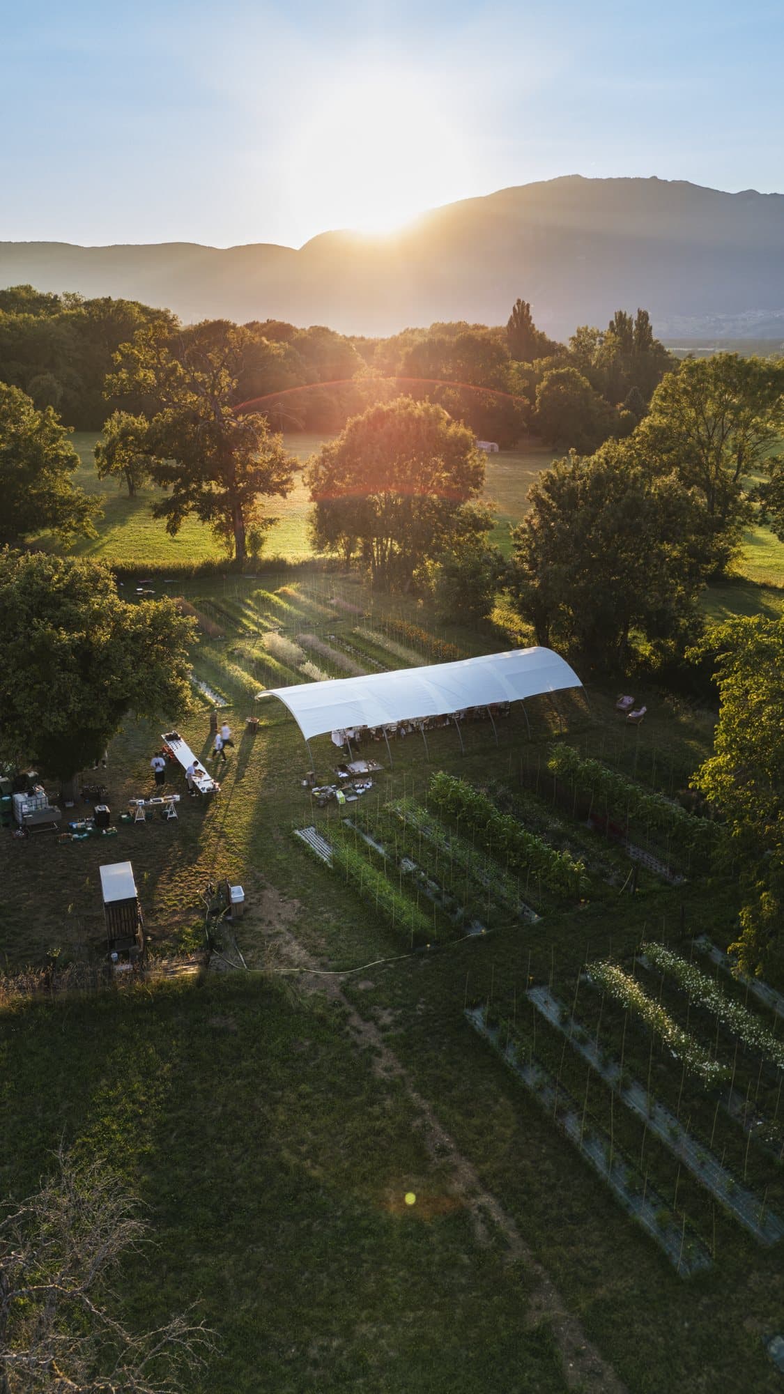 Les Jardins Agapé au coucher du soleil, la table dressée sous la serre